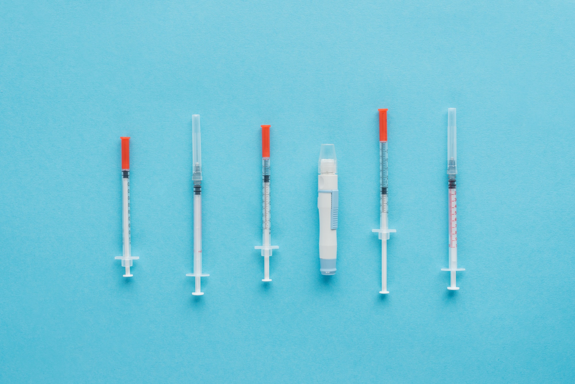 top view of insulin syringes for diabetes on blue background