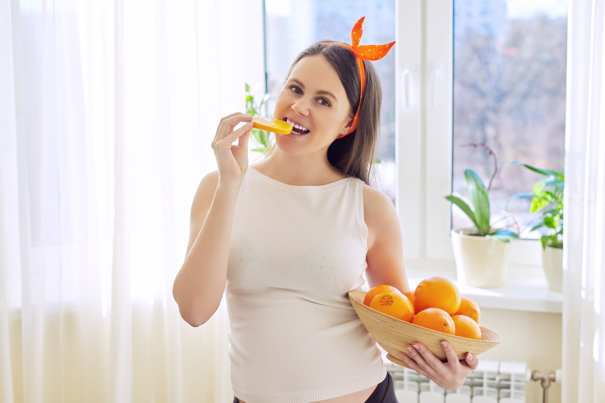 Healthy vitamin food, Beautiful happy pregnant young woman with oranges